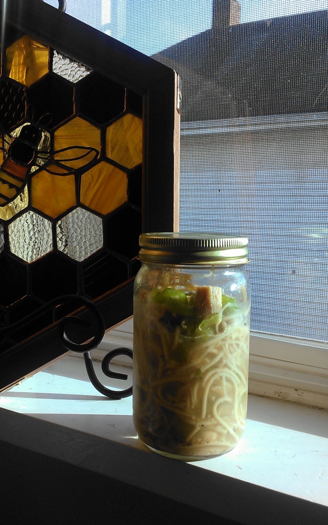 This batch of homemade chicken noodle soup contained chunks of chicken meat, celery, some leftover bacon, and pepper. Re-using an almond butter jar makes getting to work spill-free!