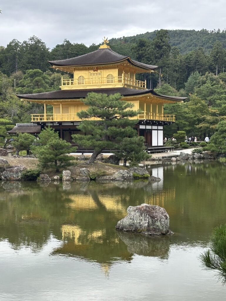 A beautiful gold-covered temple next to reflective water.